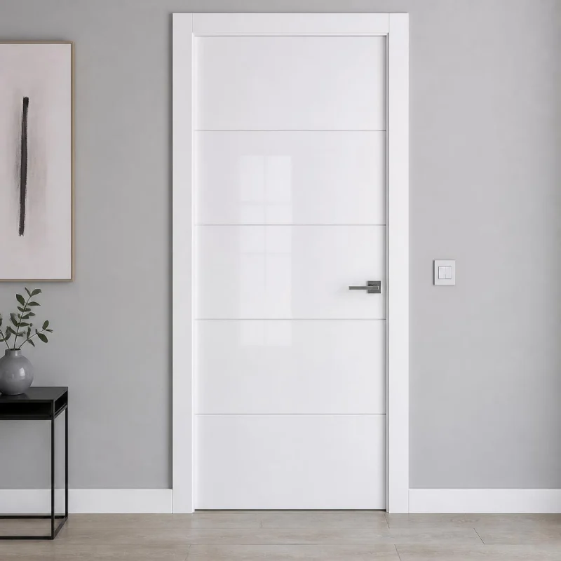 Puerta interior blanca con paneles horizontales, manilla metálica moderna y decoración minimalista con mesa negra, jarrón gris con hojas verdes y cuadro abstracto vertical.