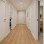Pasillo de piso con varias puertas de interior abiertas hacia dormitorio y baño