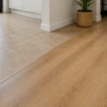 Detalle de transición entre suelo de baldosas y suelo laminado recién instalado