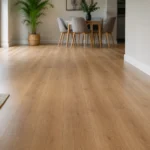 Salón y comedor con suelo laminado en tono roble claro, sofá y mesa de comedor